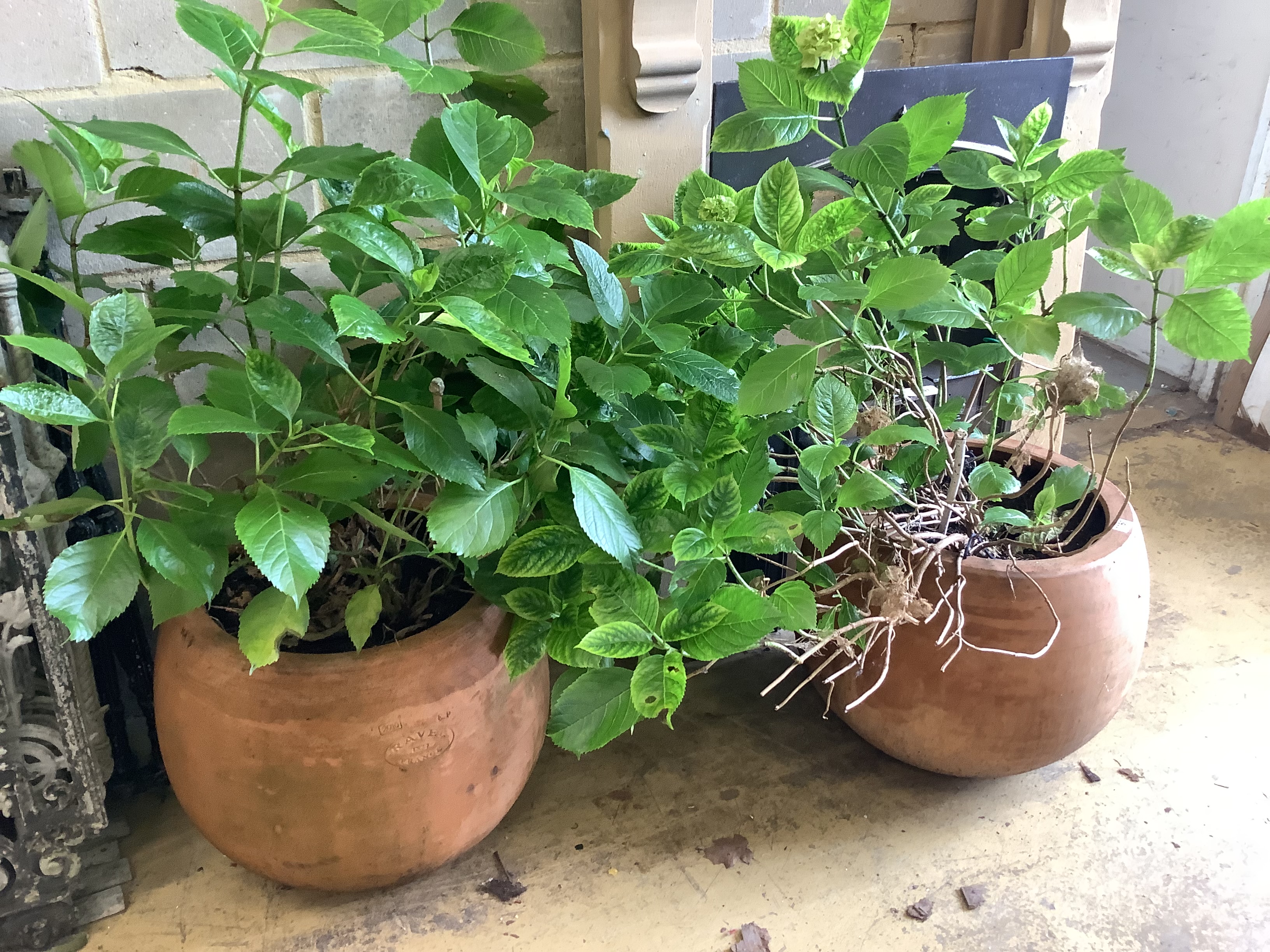 A pair of circular terracotta garden planters, stamped Ravel, France, diameter 45cm, height 40cm